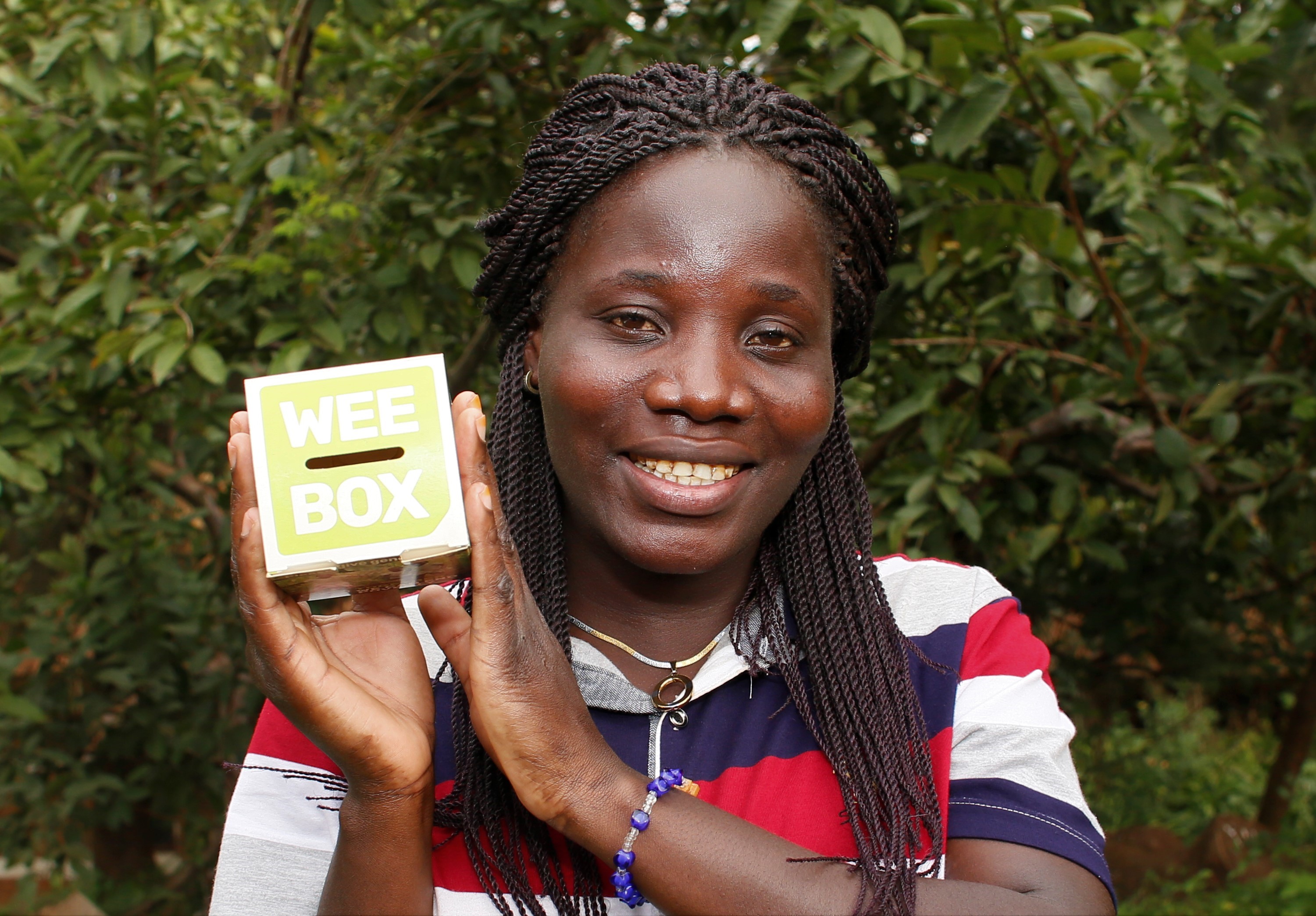 Campaign image for SCIAF's Wee Box Big Change appeal featuring a woman holding a 'wee' donation box.