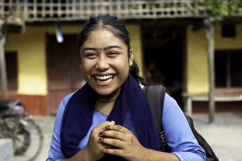 Sandhya, 17, smiling in her school uniform outside her home in Lahan, Nepal. Credit: Mani Karmacharya/WaterAid