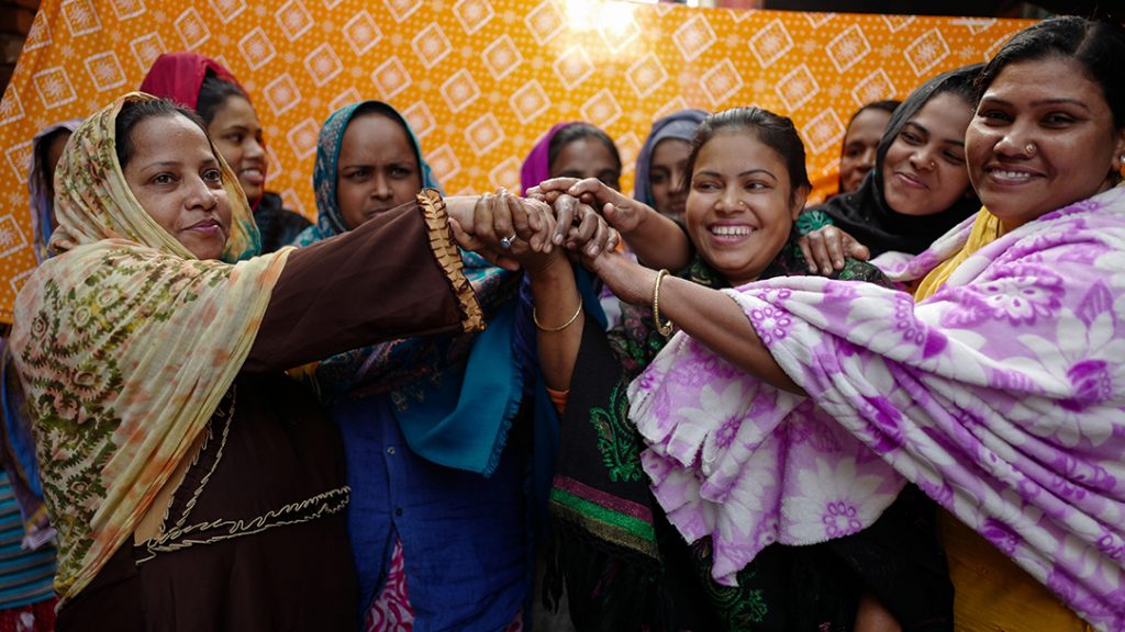 Women's Squad members join hands in solidarity, with smiles on their faces. British Red Cross image.