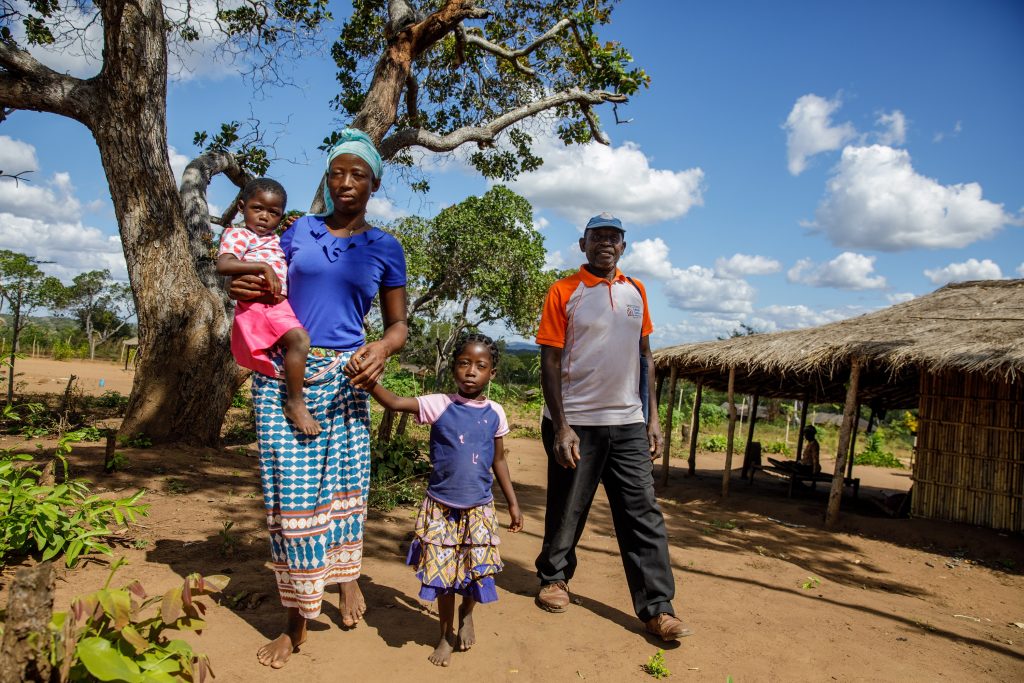 A woman and her children stood together holding hands, and a man stood by the side of them