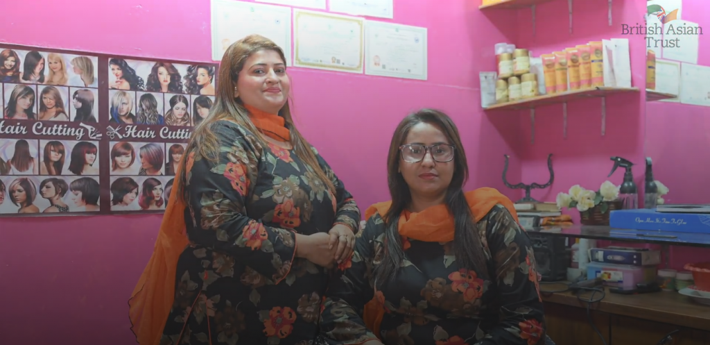Two women in their beauty salon with pink walls
