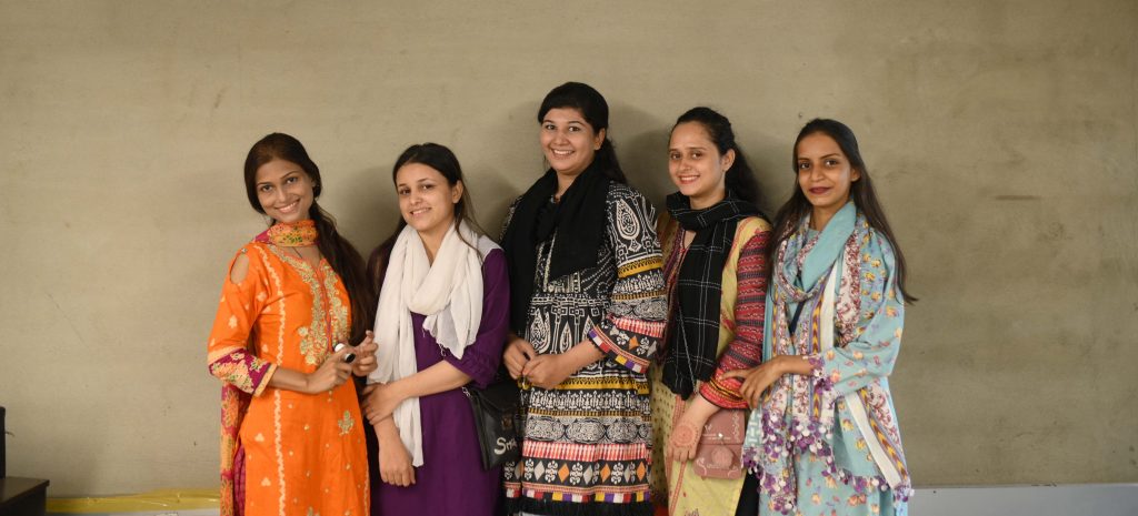 A group of five women stood in a line smiling
